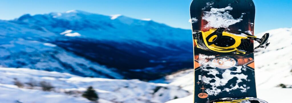 A snowboard standing upright in the snow on a mountain in the Alps