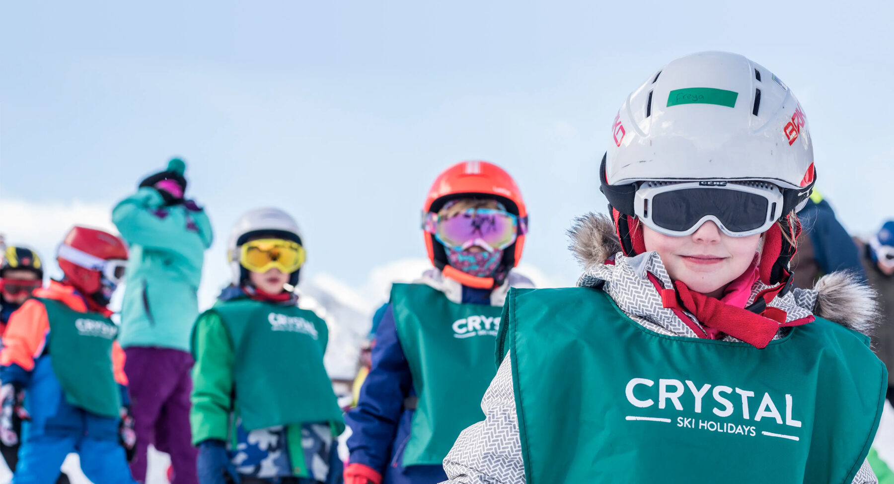 Children skiing wearing Crystal Ski School bibs